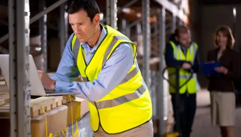 Man on computer in warehouse