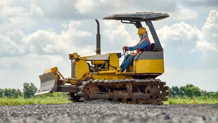 Worker sitting in a small bulldozer.