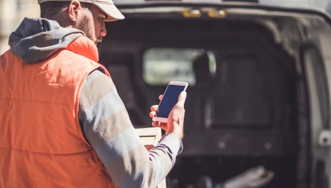 Delivery person reading app on mobile phone regarding proof of delivery