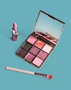 Pink eyeshadow palette, eyeshadow brush, and pink lipstick tube