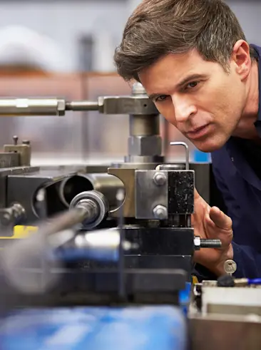 Working on a machine in a factory.