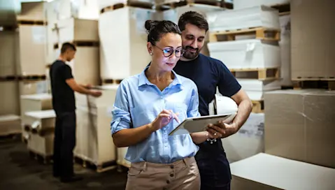 Man woman on tablet in warehouse