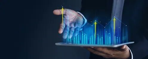 Hands holding a tablet displaying a graph showing something rising.