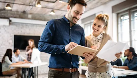 Man and woman looking at tablet in office