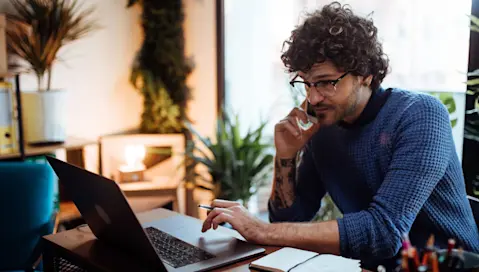 person on phone and laptop