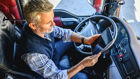 Truck driver with tablet device in hands