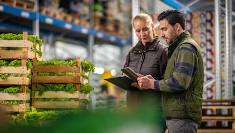 Food facility employees review information on a tablet.