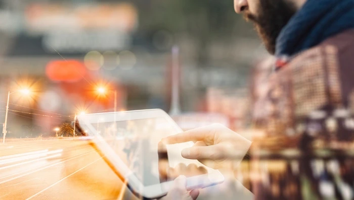 Man looking at tablet on the street.