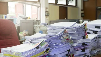piles of paperwork on desk