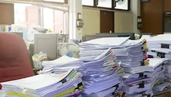 piles of paperwork on desk