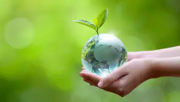 A crystal globe sprouts a healthy seedling, a symbol for more sustainable manufacturing.