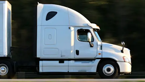 A large heavy goods vehicle travels at speed on a road.