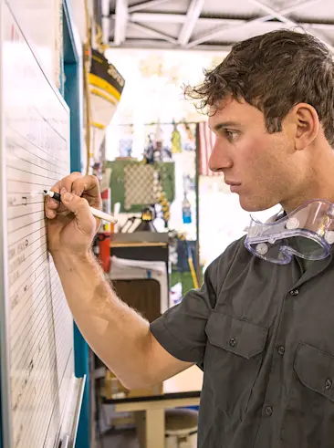 Shop worker writing on job board