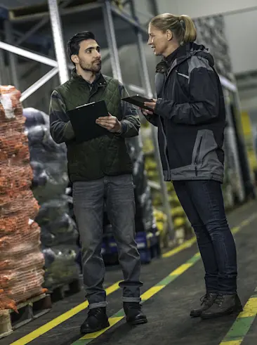 Two people counting inventory on their tablet.