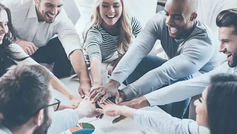 team with hands in on top of one another