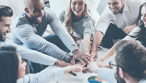 team with hands in on top of one another
