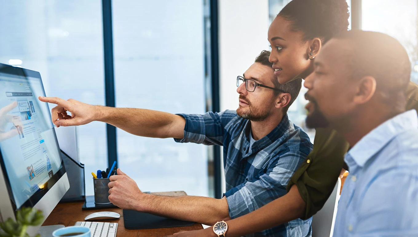 Colleagues at work looking at monitor screen