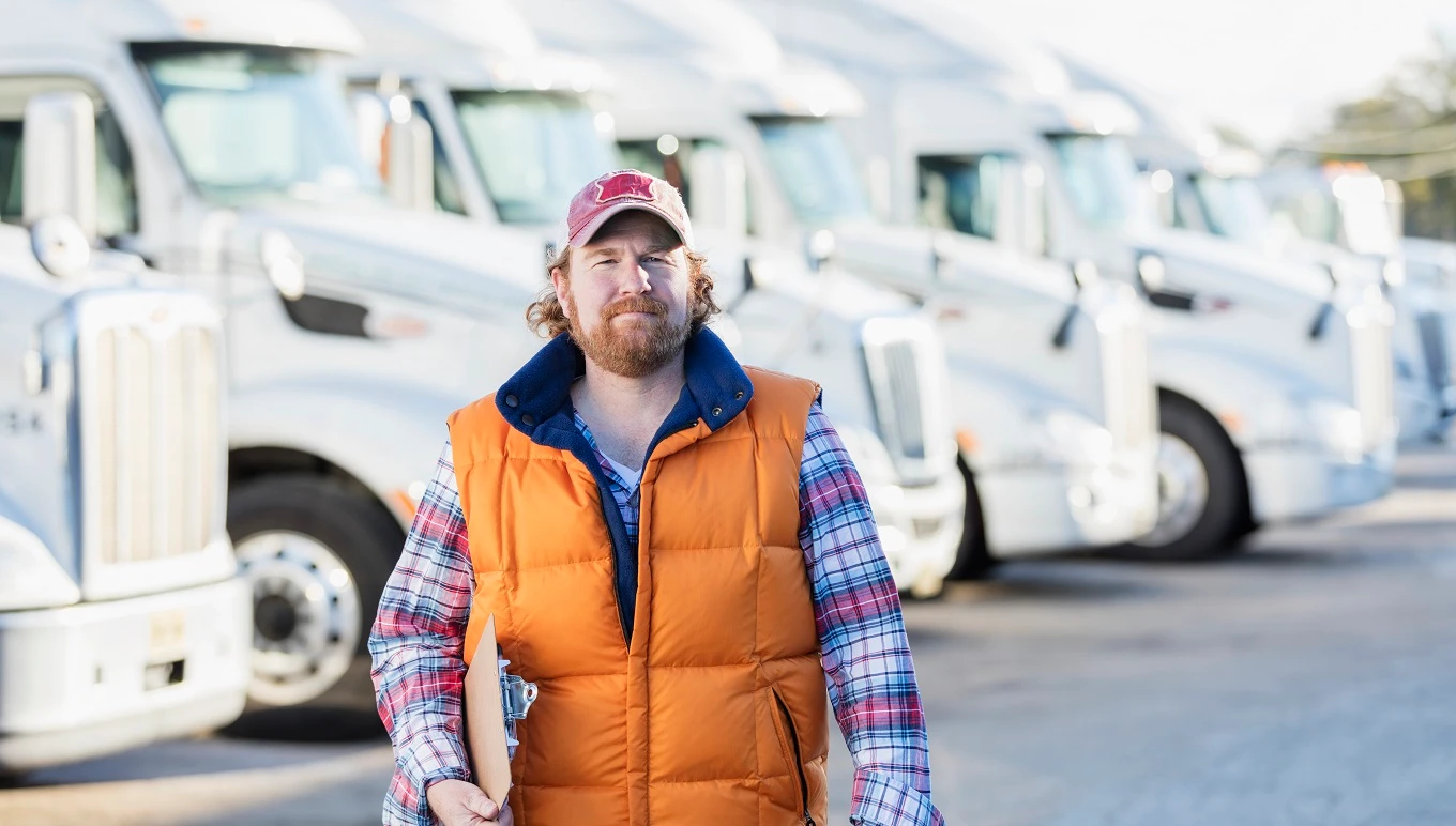 Man walking in parking lot of truck fleet.