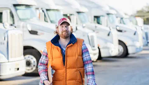 Man walking in parking lot of truck fleet.