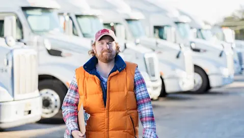 Man walking in parking lot of truck fleet.