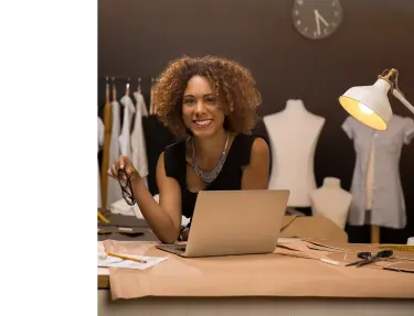 Mujer sonriendo detrás de un portátil