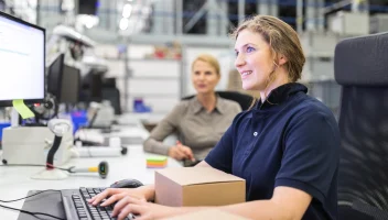 Women at shipping desk with boxes and processing orders