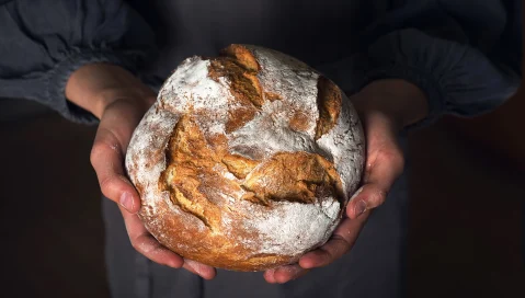 Baker holding loaf of bread