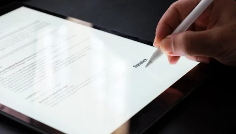 Person signing contract on tablet