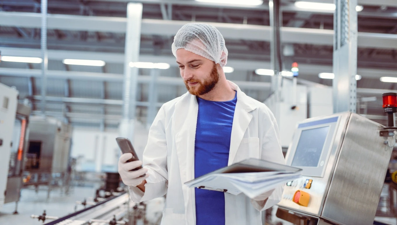 A food and beverage business employee using mobile ERP functionality on the factory floor.