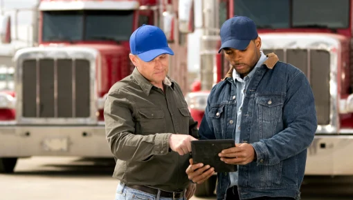 Two truck drivers using handheld device
