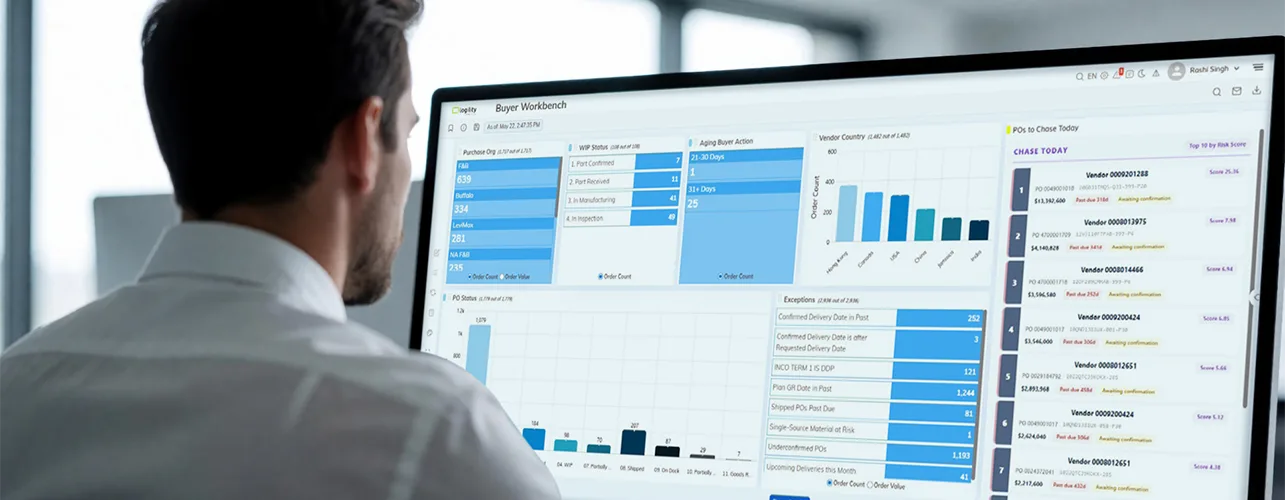 A man sitting in front of a screen displaying Buyer Workbench data.