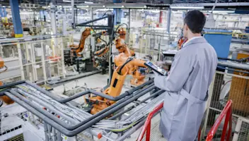 Factory engineer using tablet on stairs