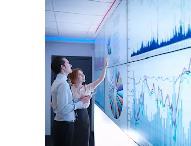 Two individuals analyzing data on a board.