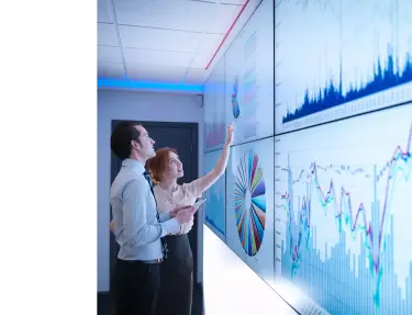 Two individuals analyzing data on a board.