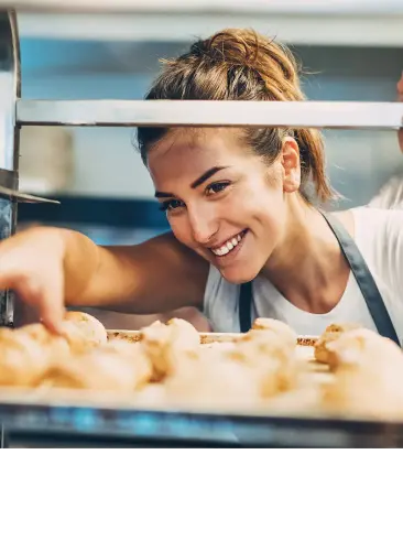 Woman in Bakery organizing baked goods on cooling racks