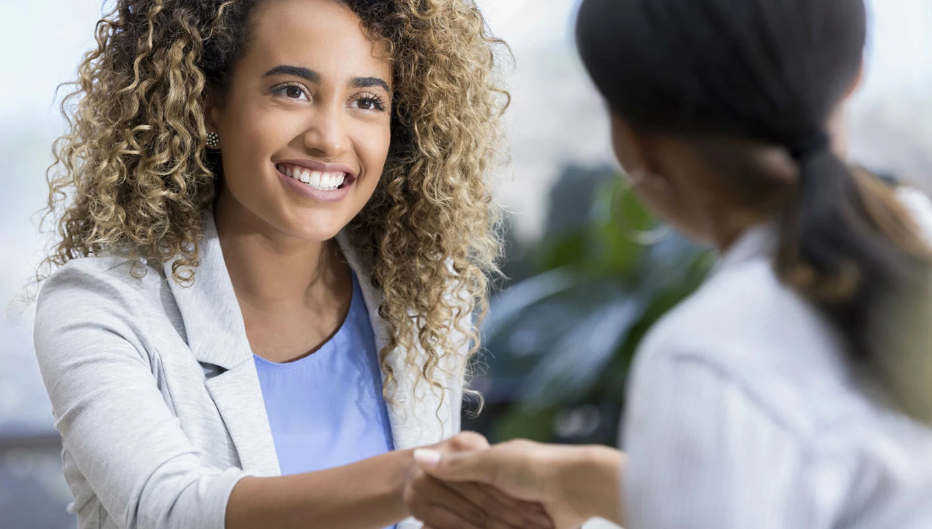 Two women shaking hands