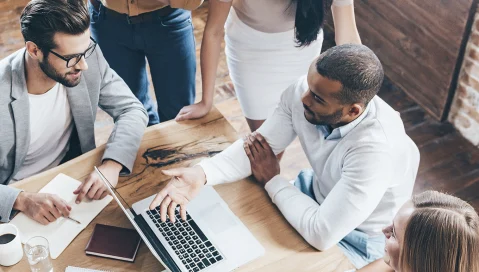  A group of people having a discussion around a laptop