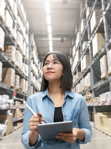 Woman counting inventory on tablet