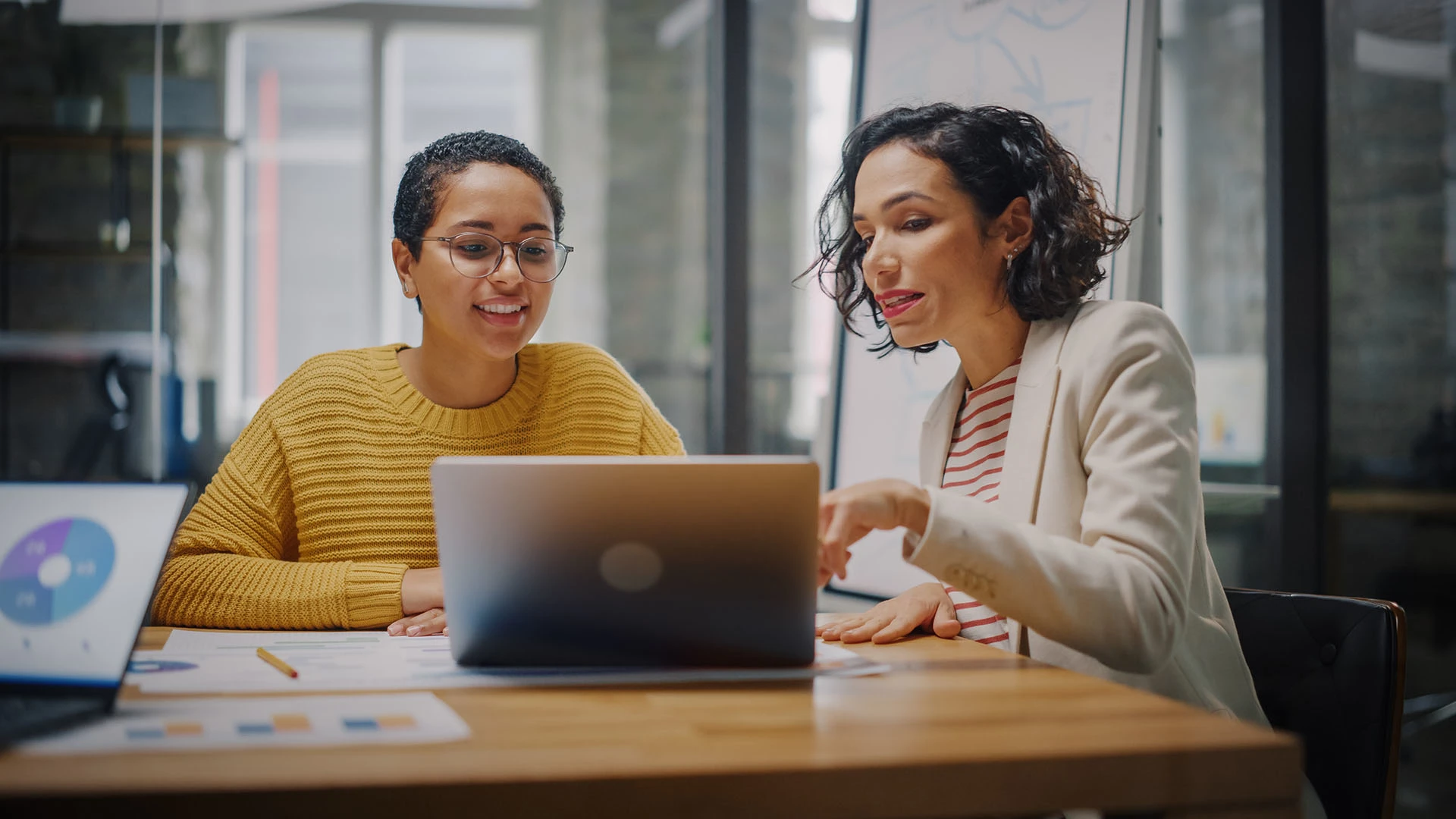 Two woman looking at laptop