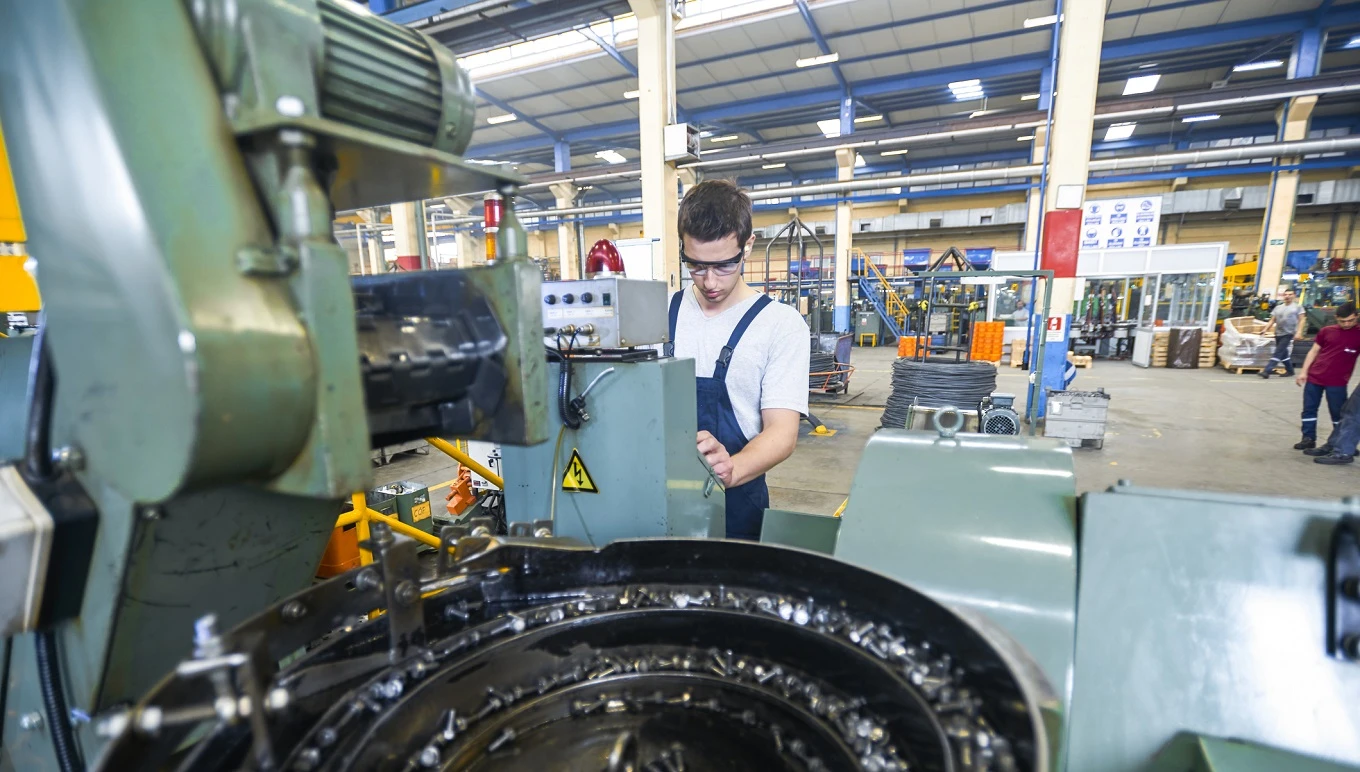 Maintenance worker operating manufacturing plant floor equipment