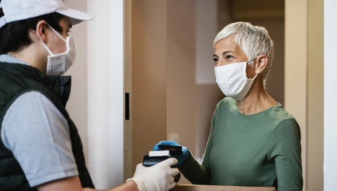 woman and delivery person wearing masks