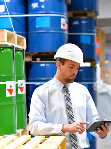 Man die inventaris opneemt op tablet van chemische fabrieksvloer.