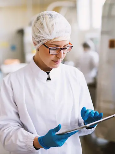 Frau in Fabrik, die ein Tablet benutzt