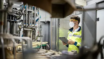 Factory working holding tablet and observing equipment