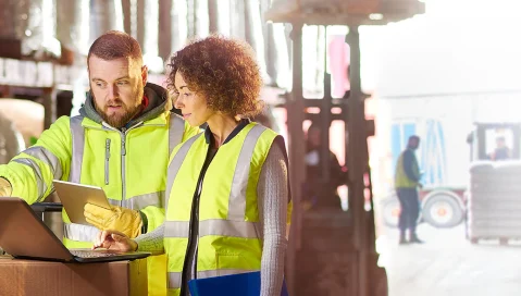 Warehouse workers with tablet and laptop