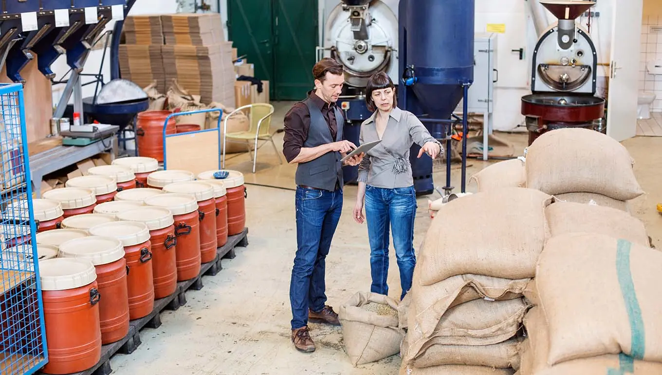 Two people in a coffee roasting factory