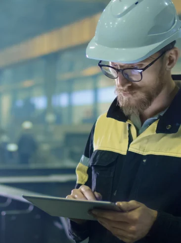 Man in a factory on a tablet.