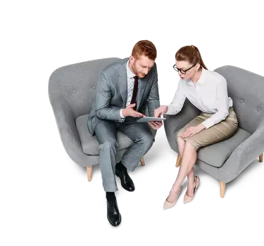 Two business professionals sitting in chairs and discussing work