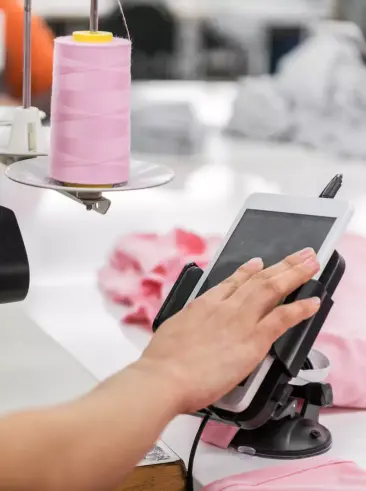 Persoon met een tablet in een kledingfabriek