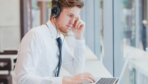 Businessman with headphones working on laptop